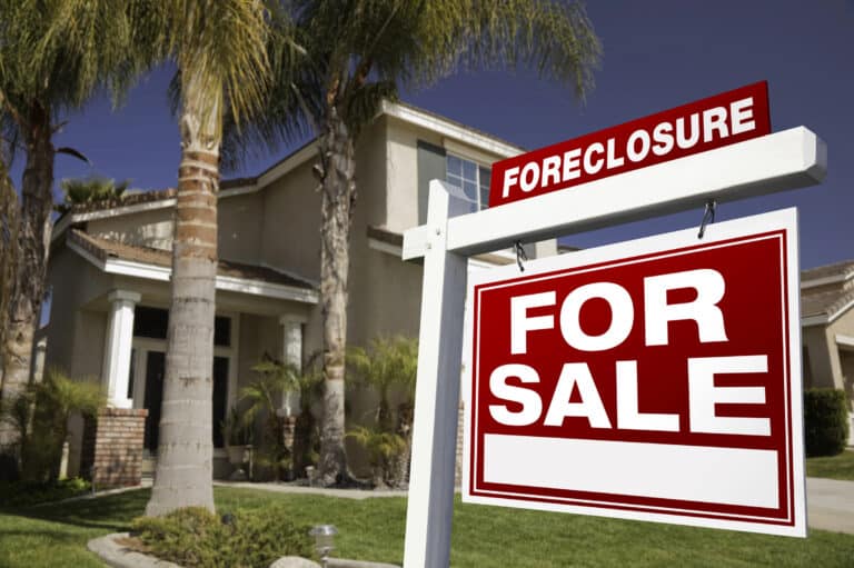 A For Sale sign with a Foreclosure notice stands in front of a two-story Florida home, highlighting the importance of protecting homeowners and lien foreclosure defense.