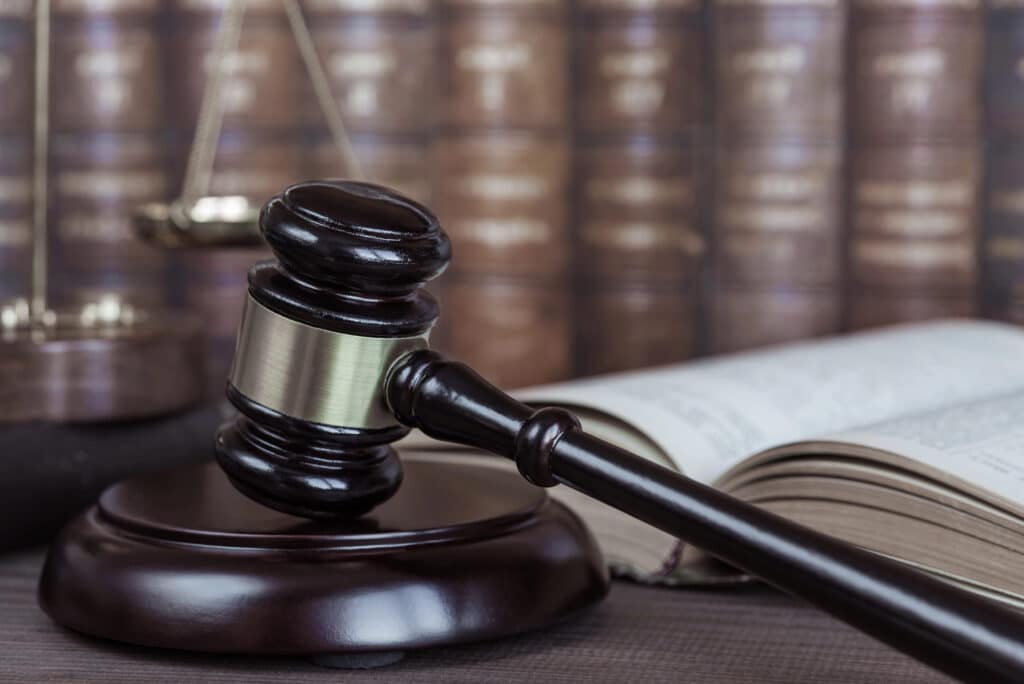 A judge's gavel rests on a sound block next to an open law book, with a stack of legal books and a balance scale—highlighting common probate mistakes.